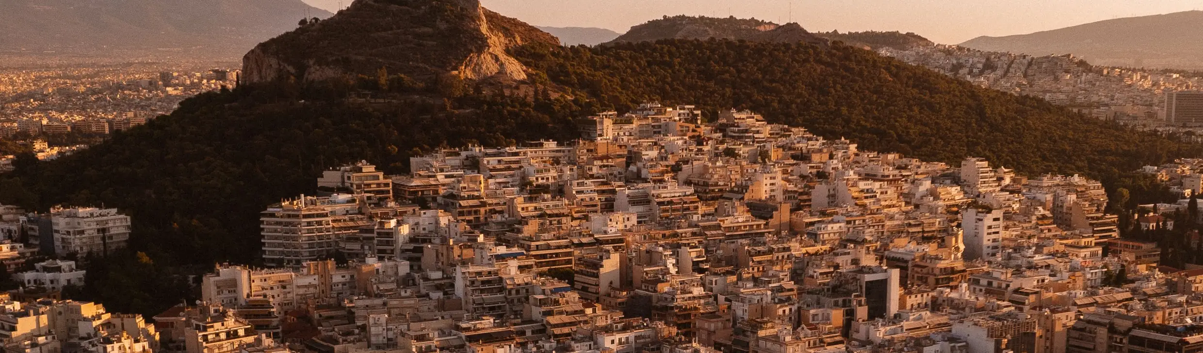 Apartment blocks climbing the slope below Lycabettus hill in Athens, late afternoon